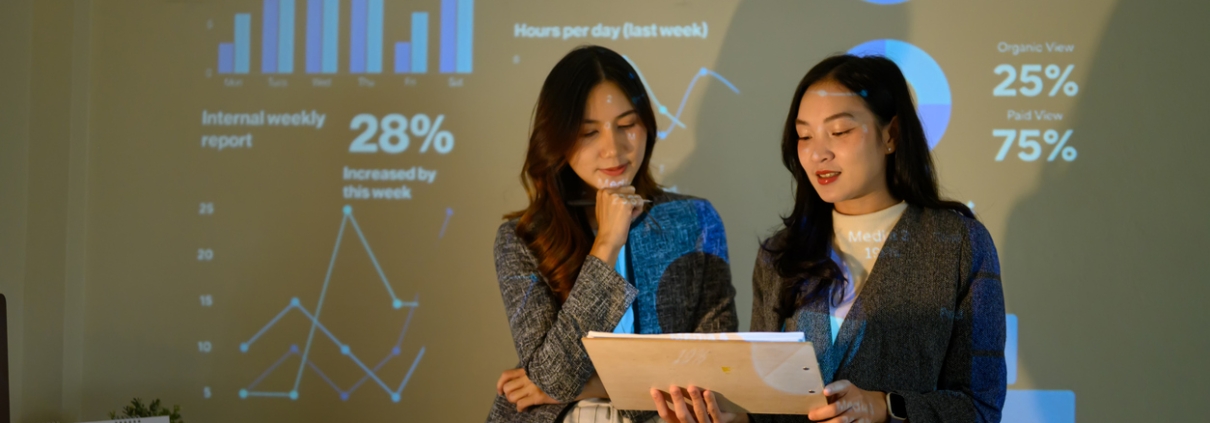 Two Businesswomen Reviewing Data During Office Presentation with Projected Charts and Analytics Dashboard first-party engagement data